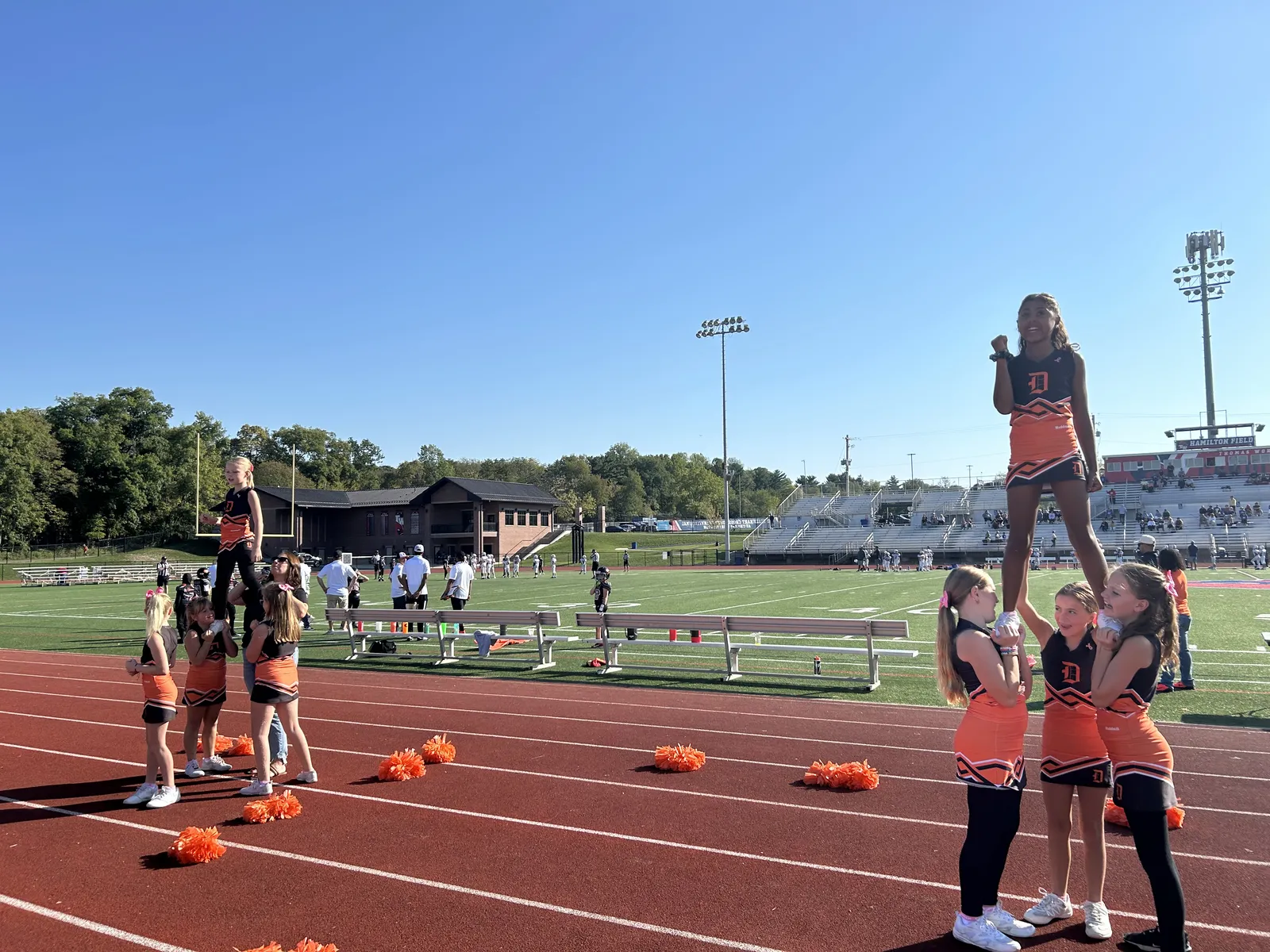Jr Pacers cheerleaders perform a stunt on the track