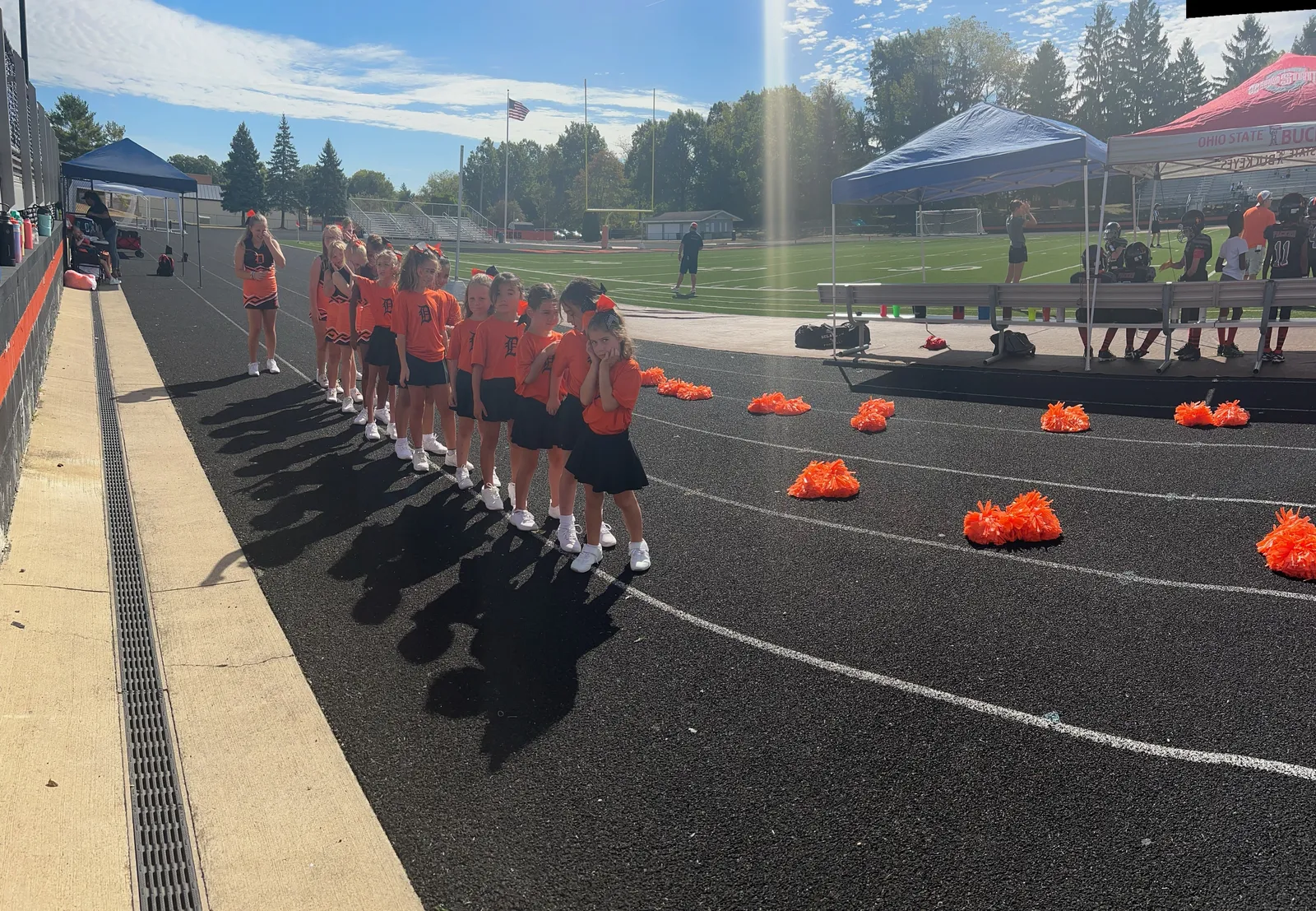 Jr Pacers cheerleaders cheering on the sideline with poms