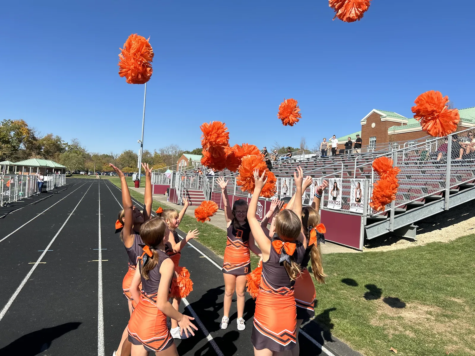 Jr Pacers cheerleaders hitting a sharp motion, poms up