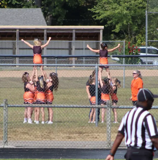 Jr Pacers cheerleaders stunting along the fence