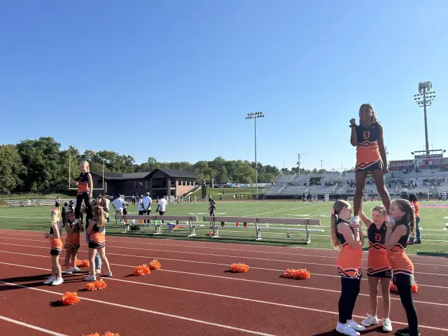 Jr Pacers cheerleaders perform a stunt on the track