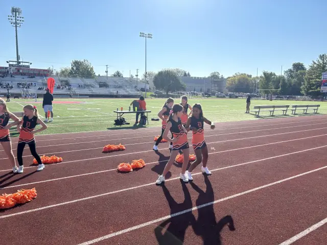 Jr Pacers cheer squad with poms on the track