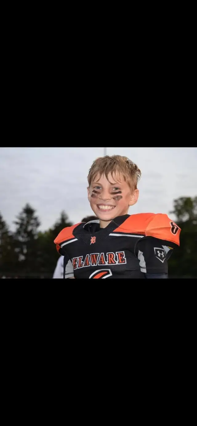 A smiling Jr Pacers player on the sideline