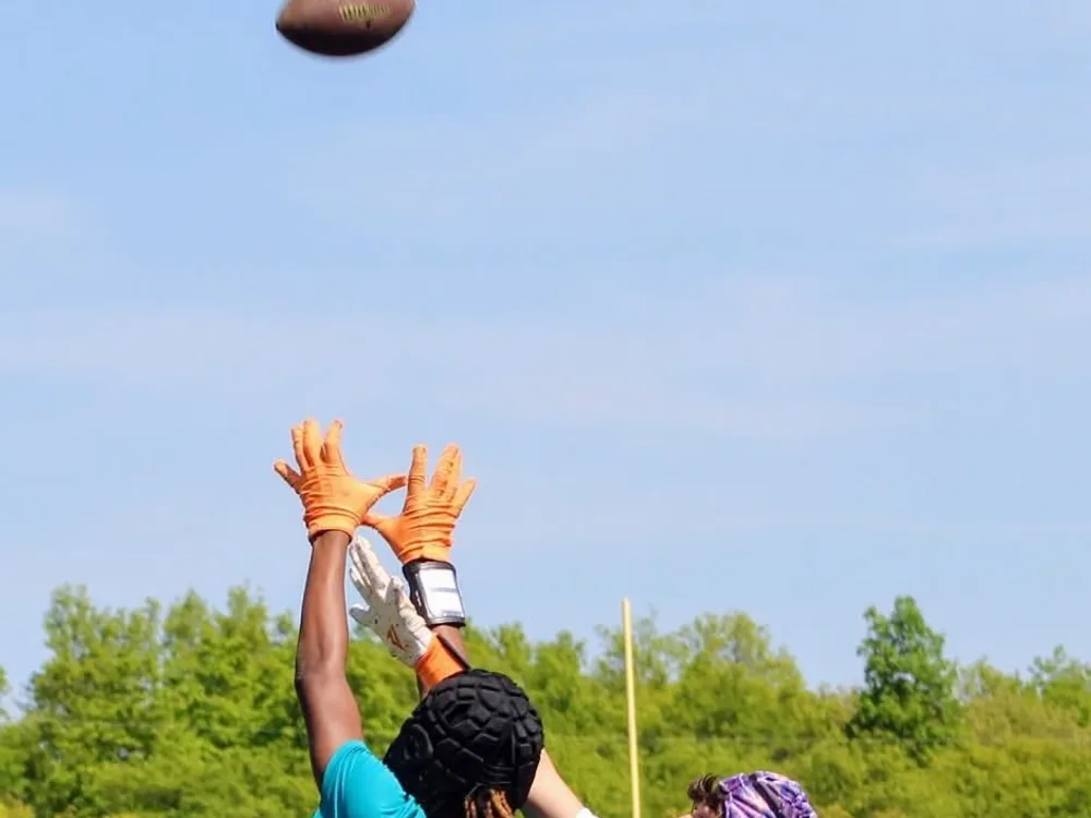 A Jr Pacers 7v7 player reaches up to catch a pass