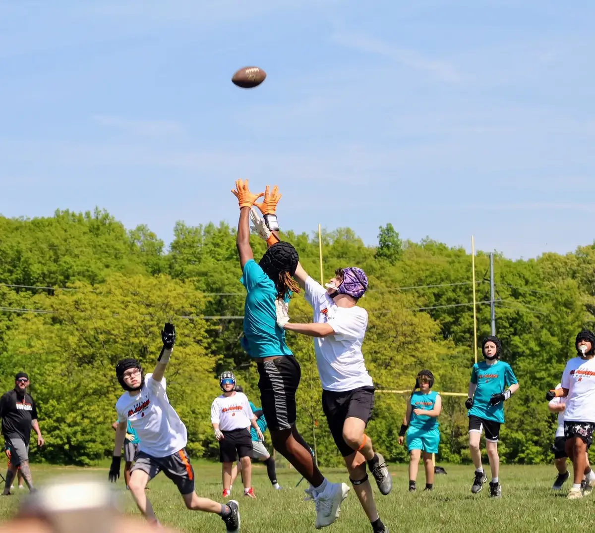 Delaware Jr Pacers players leap for a pass in a 7v7 touch game