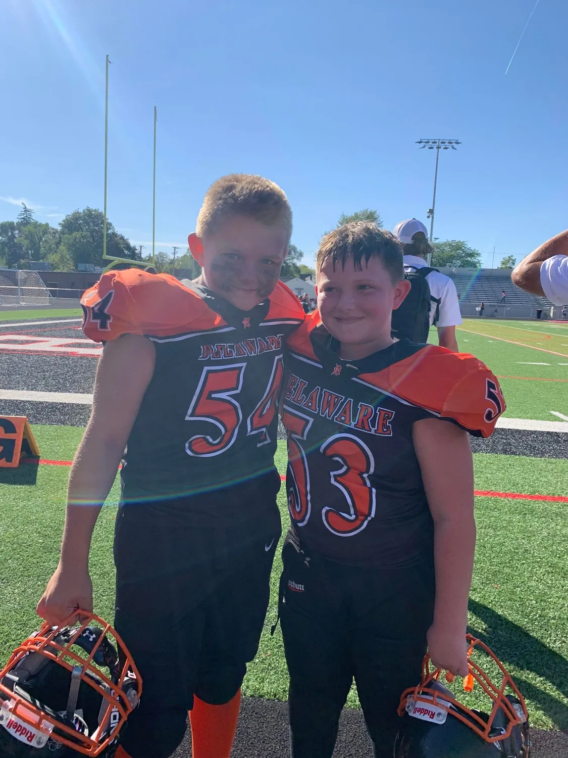 Two Jr Pacers teammates arm in arm on the field