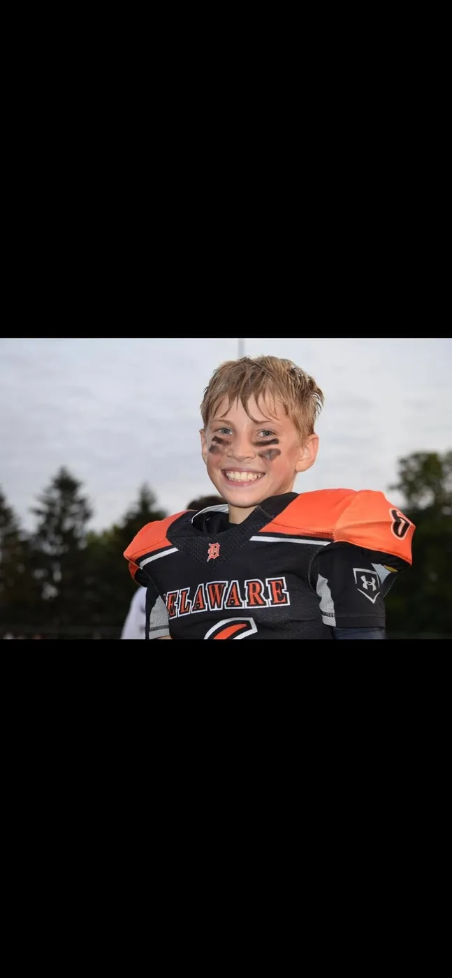 A smiling Jr Pacers player on the sideline